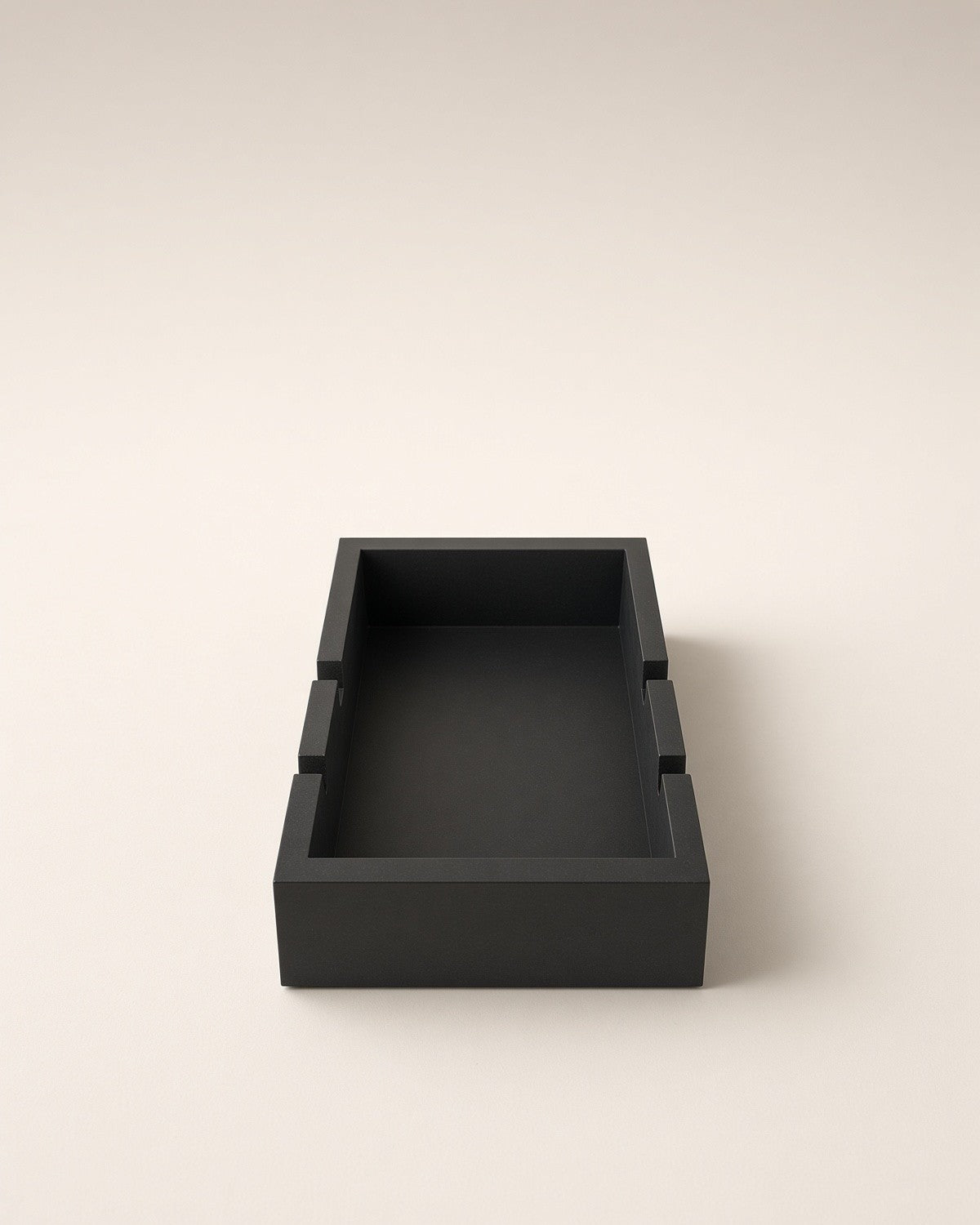 The empty black stand, showing its water well and the slots that hold the board
