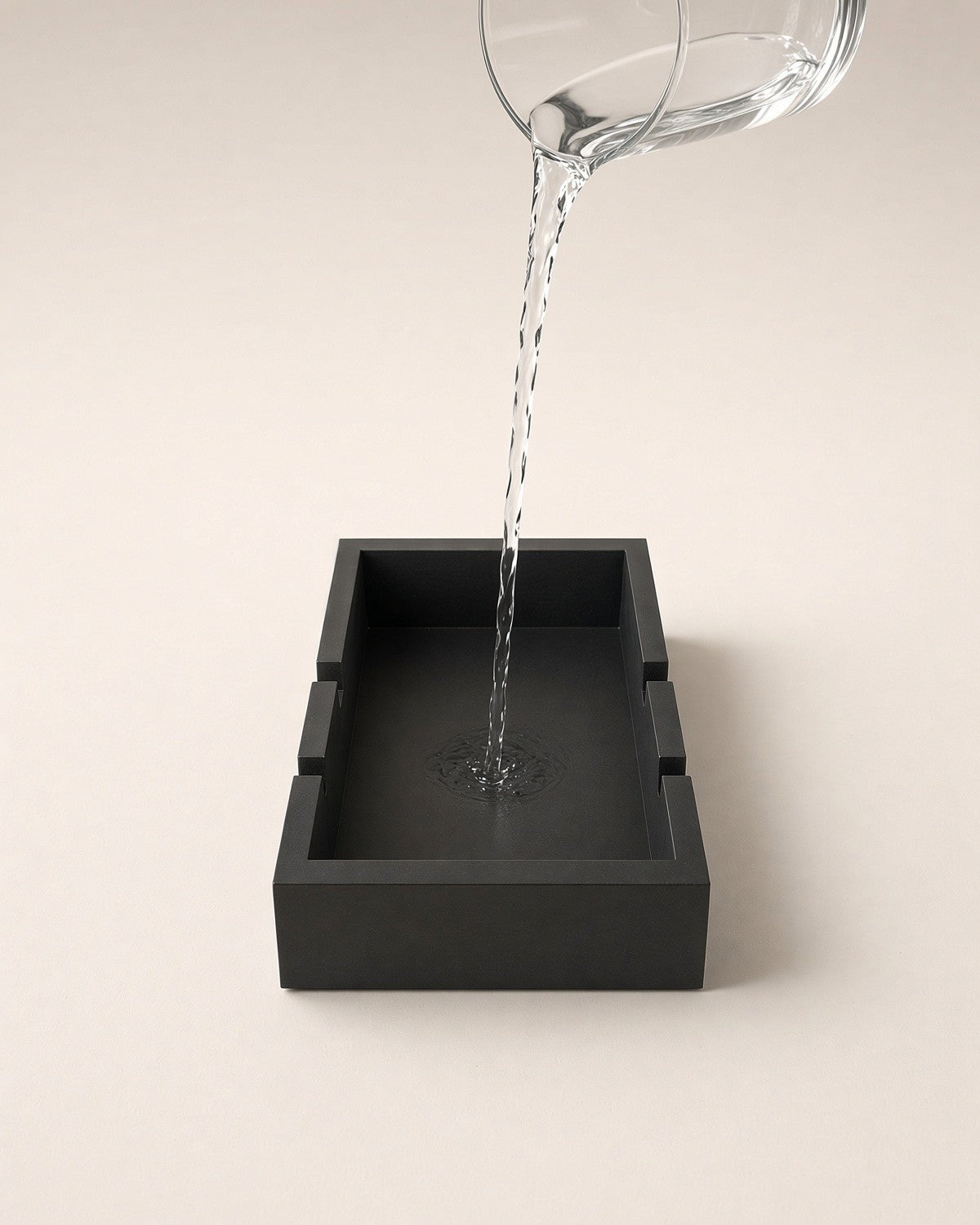 Water poured from a glass jug into the stand's water well