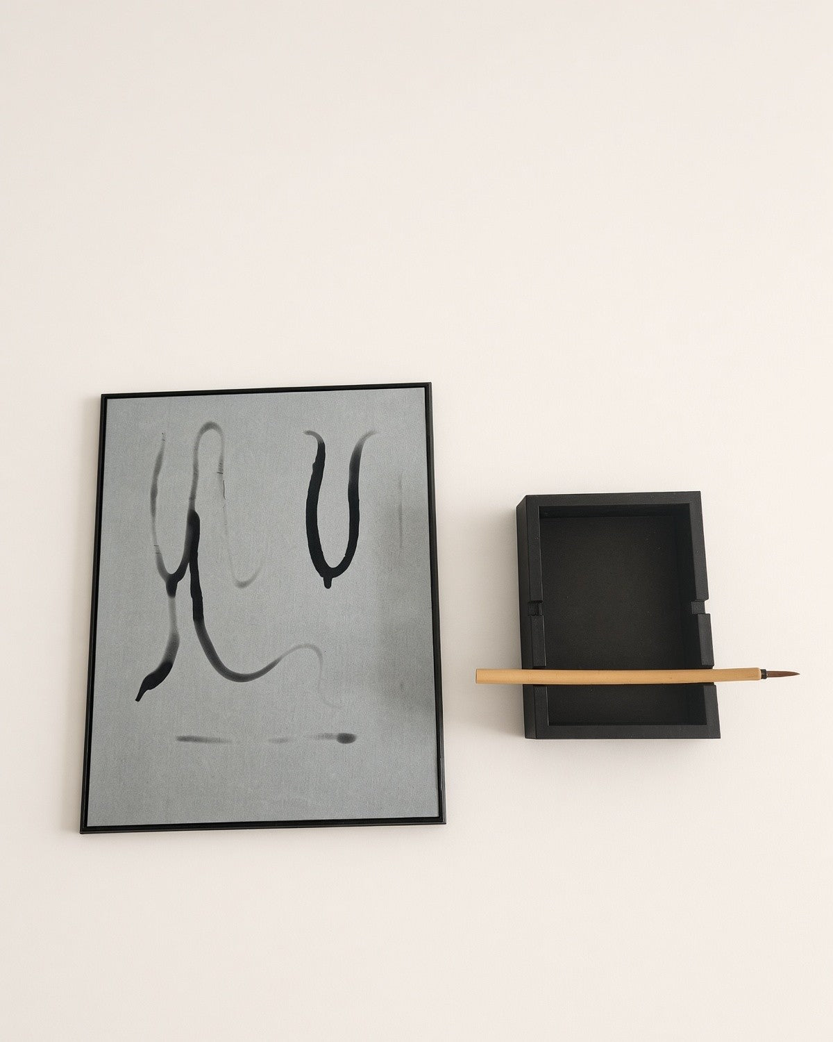 Flat lay of the board with fading water strokes, next to the stand and brush